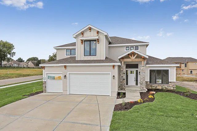 A large house with two garages and a driveway in a residential area.