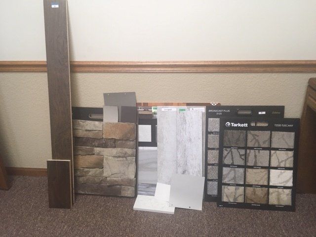 A variety of tiles and wood samples are on the floor