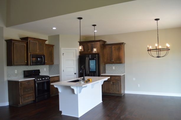 An empty kitchen with a large island in the middle