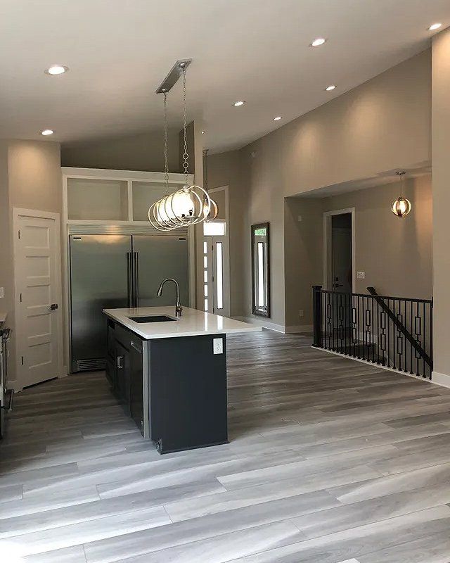 A kitchen with a large island and a refrigerator.