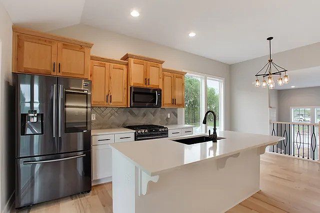 A kitchen with stainless steel appliances and wooden cabinets.