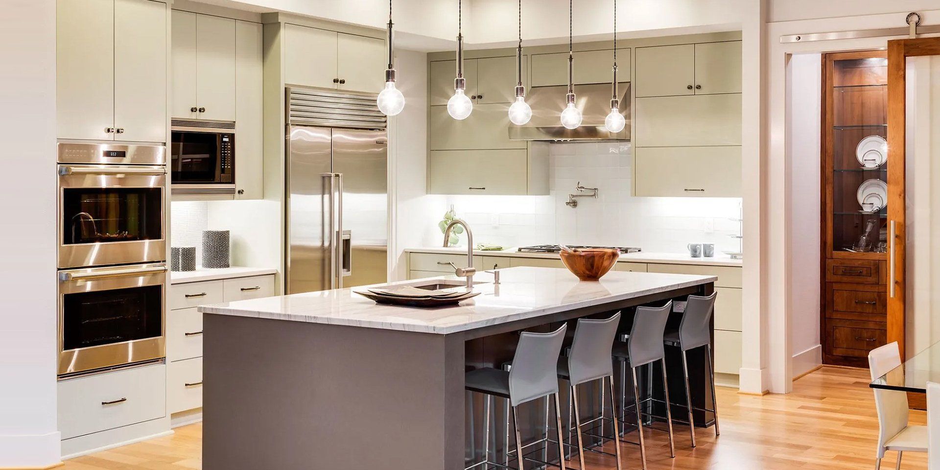 A kitchen with stainless steel appliances and a large island.