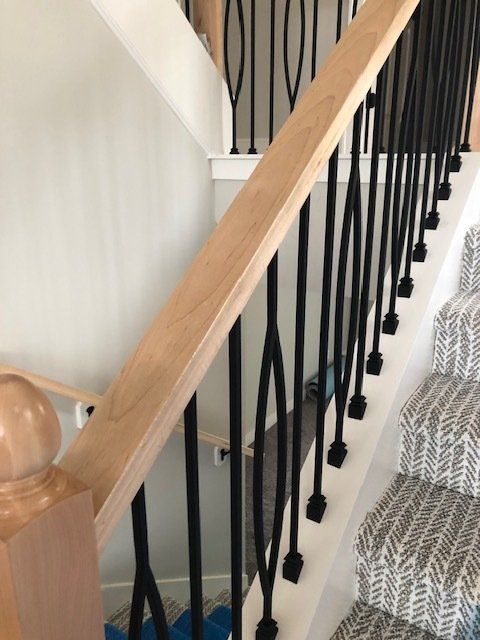 A staircase with a wooden handrail and black railing