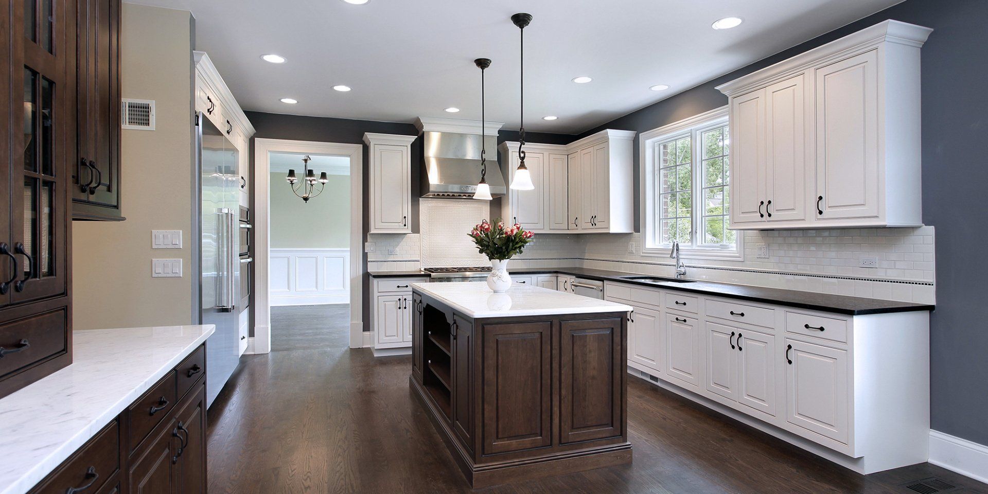 A large kitchen with white cabinets and a large island in the middle.