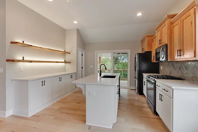 A kitchen with white cabinets and a large island in the middle