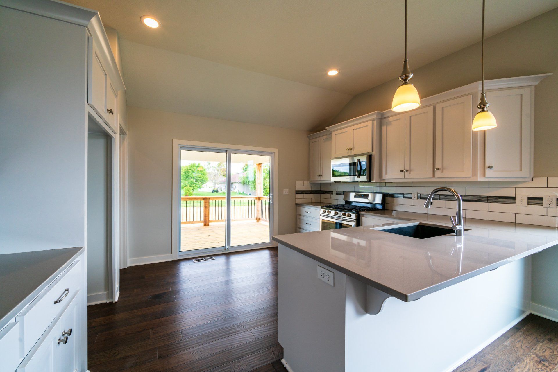 An empty kitchen with white cabinets and a large island.