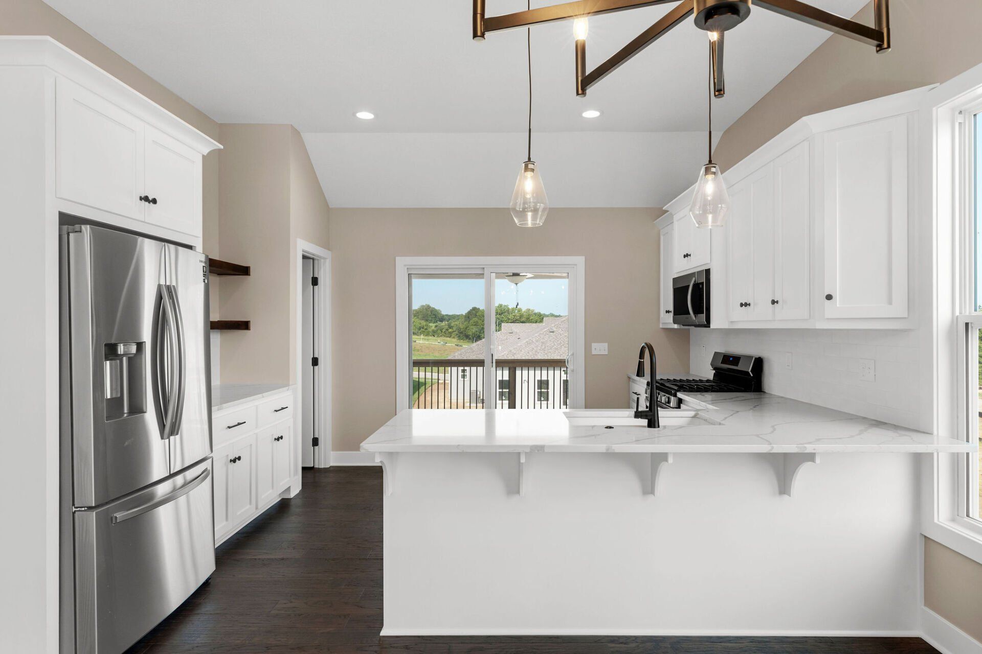 A kitchen with white cabinets , stainless steel appliances , and a large island.