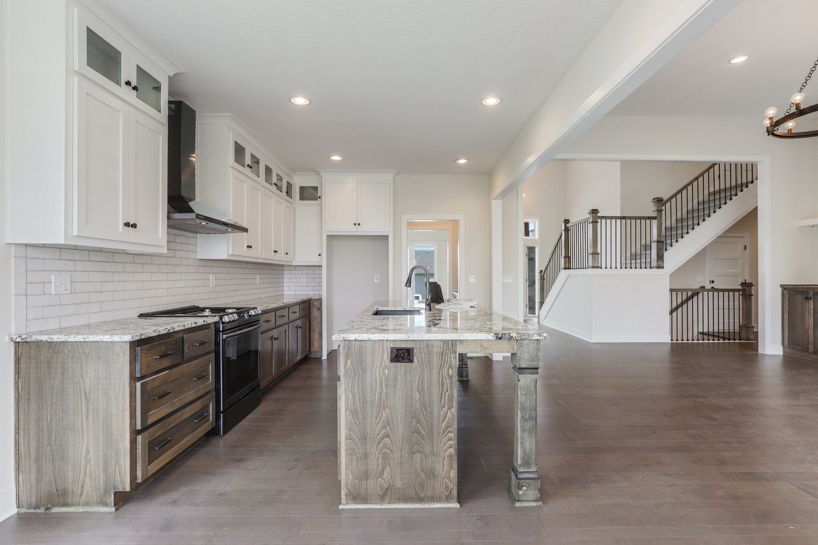 A kitchen with white cabinets , stainless steel appliances , and a large island.