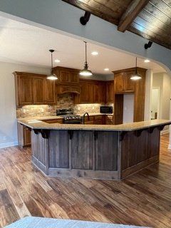 A kitchen with wooden cabinets and a large island in the middle.