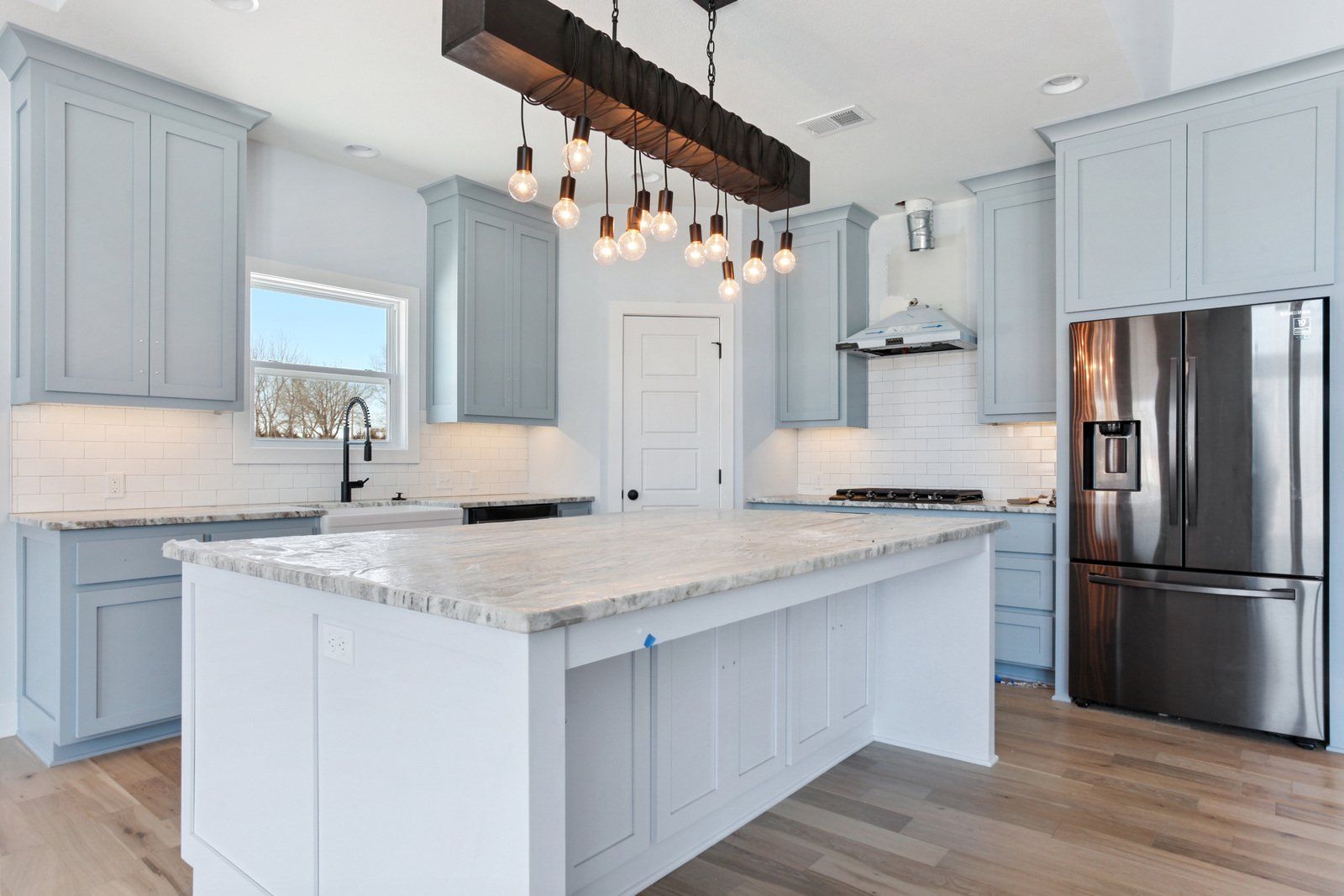 A kitchen with stainless steel appliances and a large island.