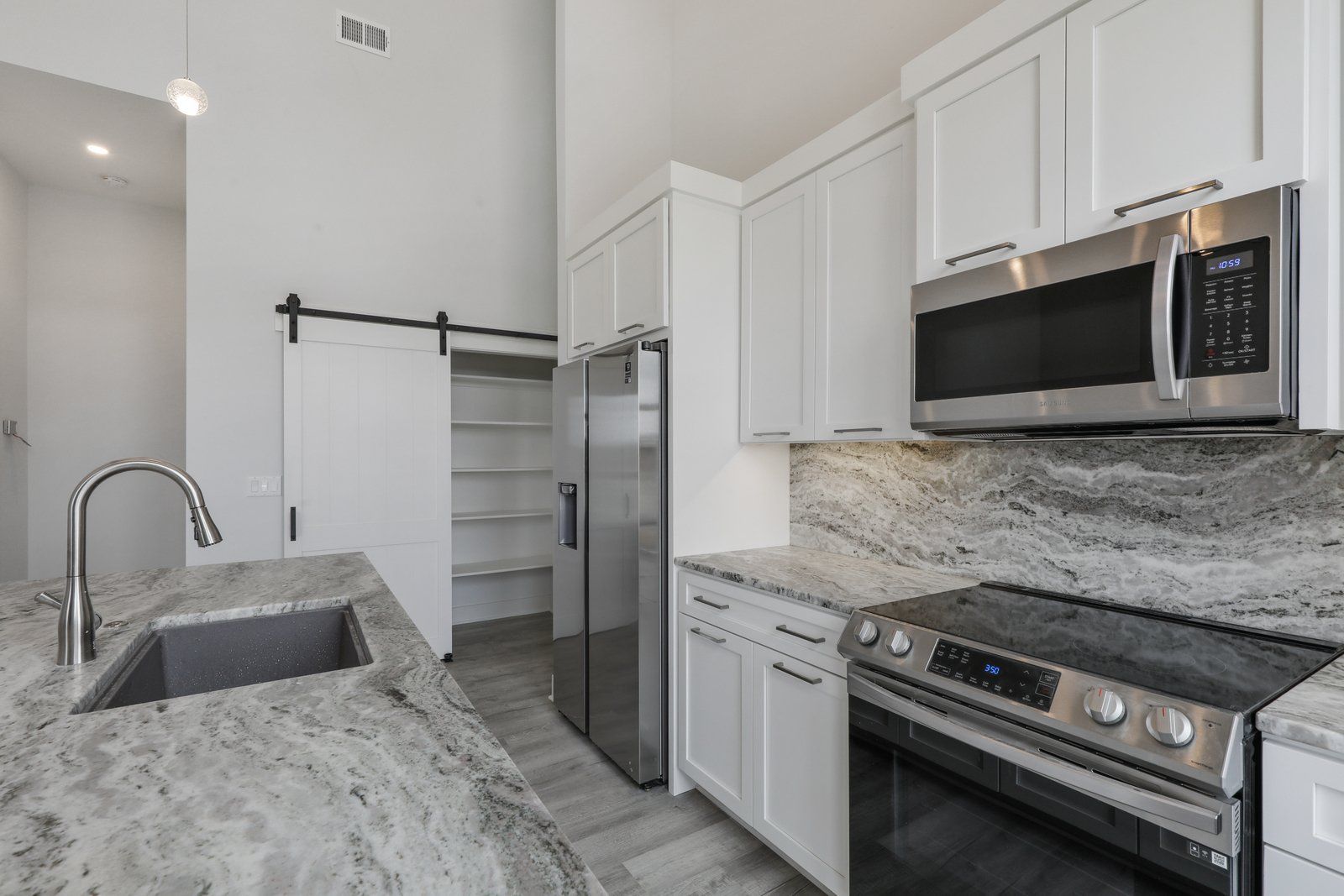 A kitchen with stainless steel appliances and granite counter tops.