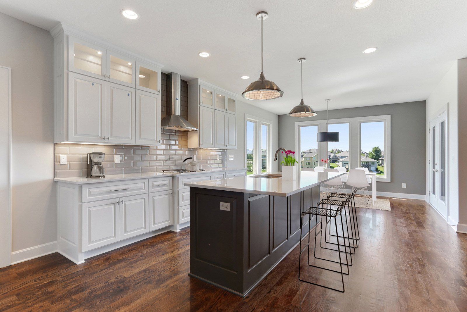 A kitchen with white cabinets and a large island in the middle.