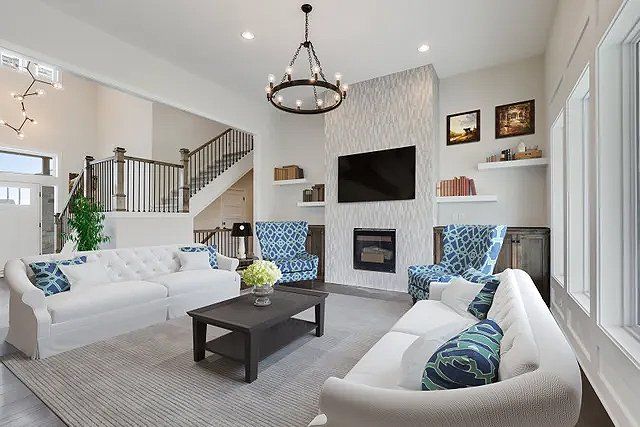 A living room with a couch , chairs , coffee table and television.