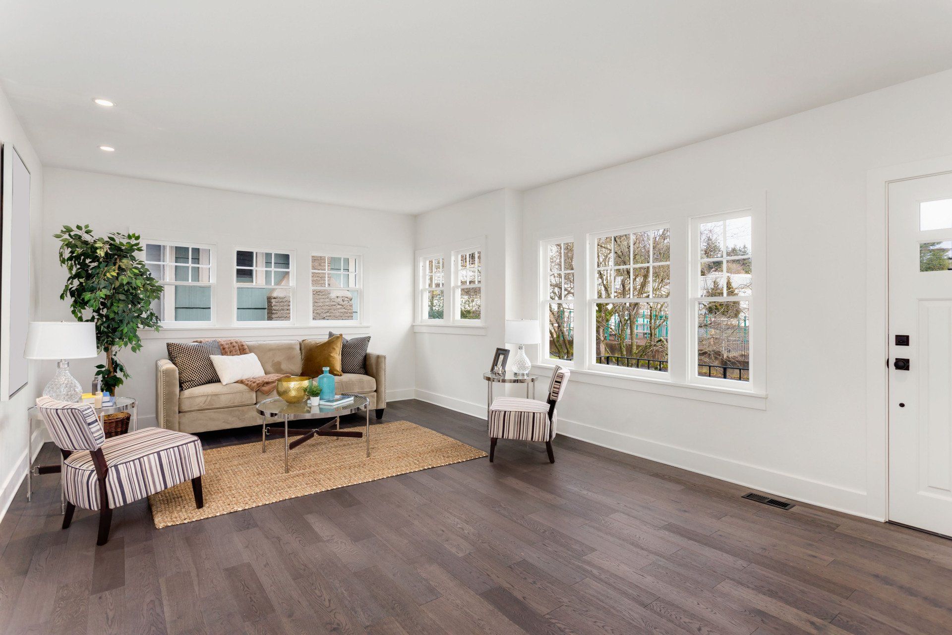 An empty living room with a couch , chairs , and a table.