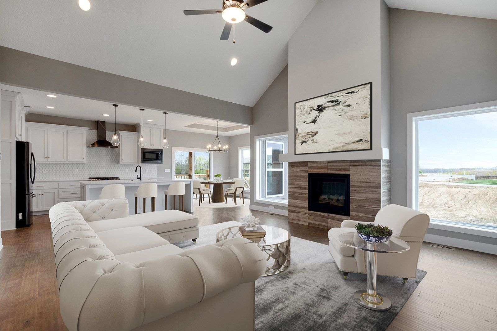 A living room with a couch , chairs , a fireplace and a ceiling fan.