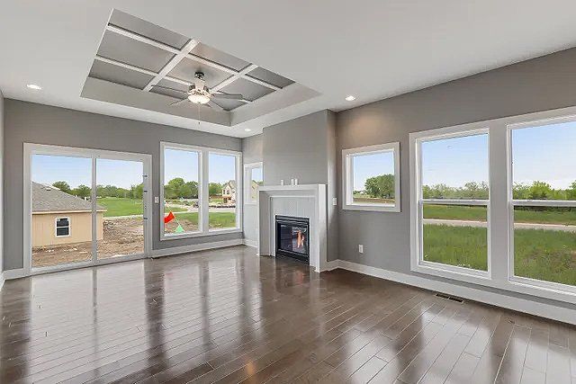 An empty living room with hardwood floors and a fireplace.