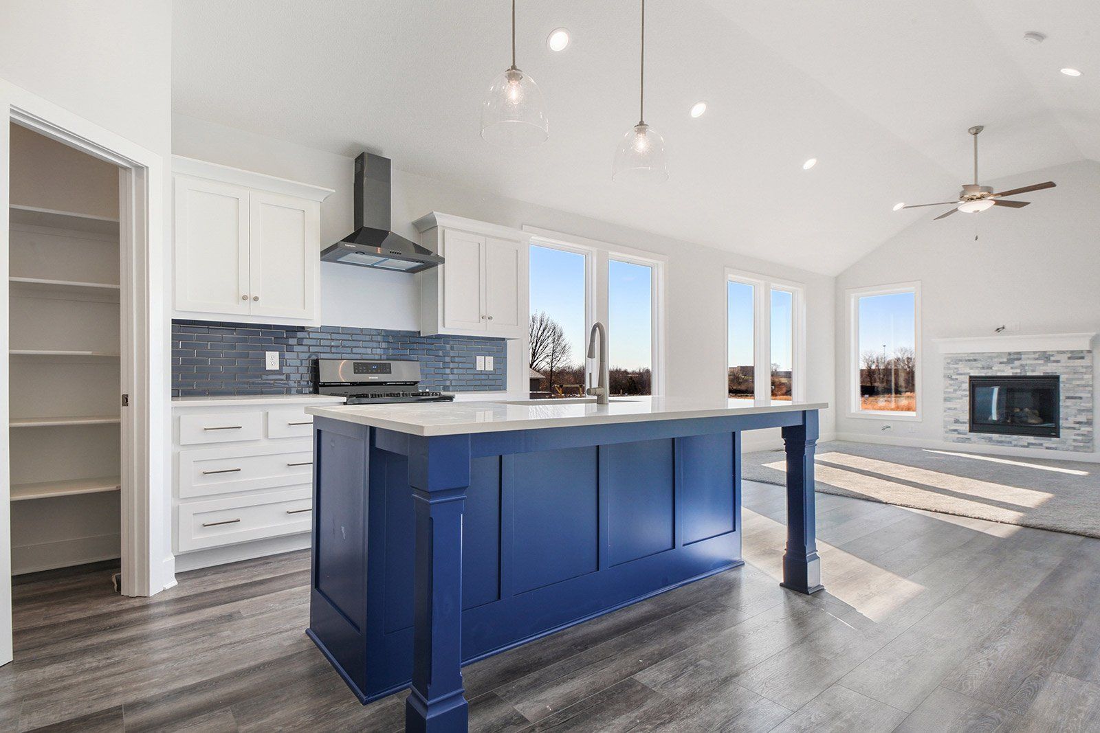 A kitchen with a large blue island and white cabinets.