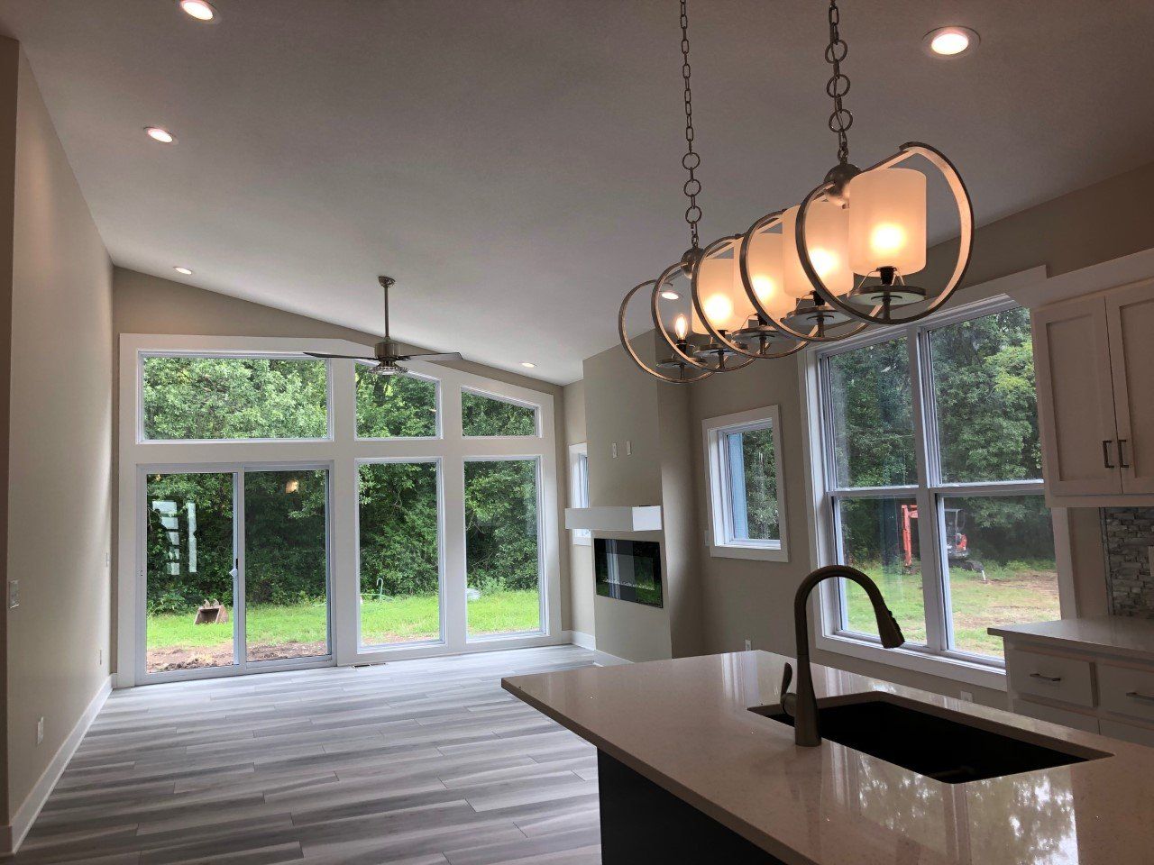 A kitchen with a sink and a chandelier hanging from the ceiling.