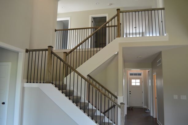 A staircase in an empty house with a wooden railing