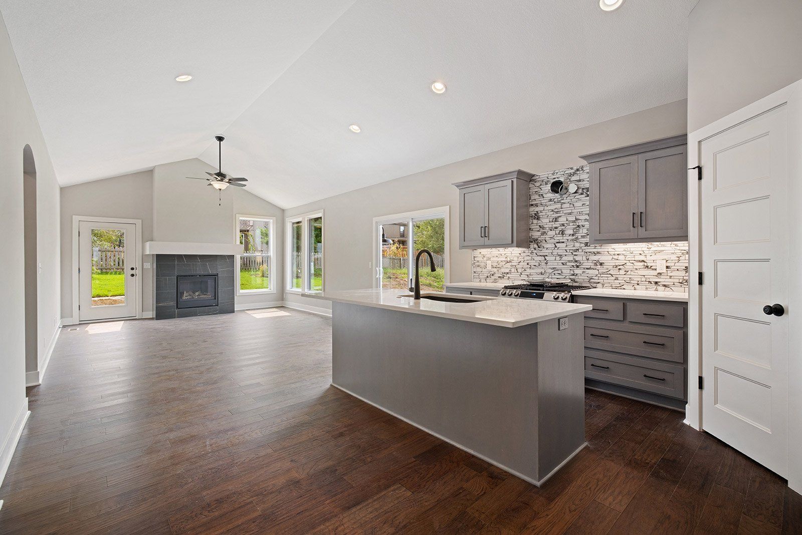 A kitchen with a large island and a fireplace in a house.