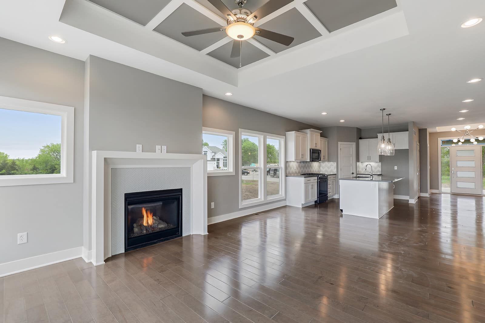An empty living room with a fireplace and a ceiling fan.