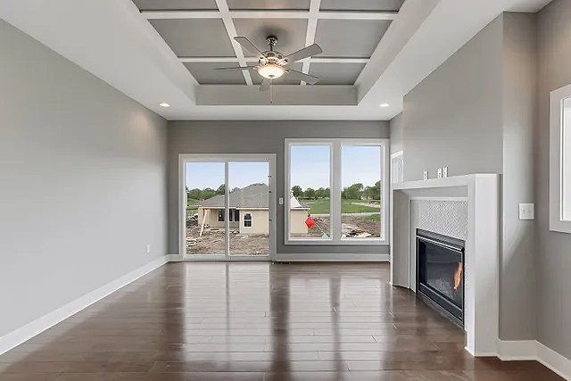 An empty living room with hardwood floors and a fireplace.