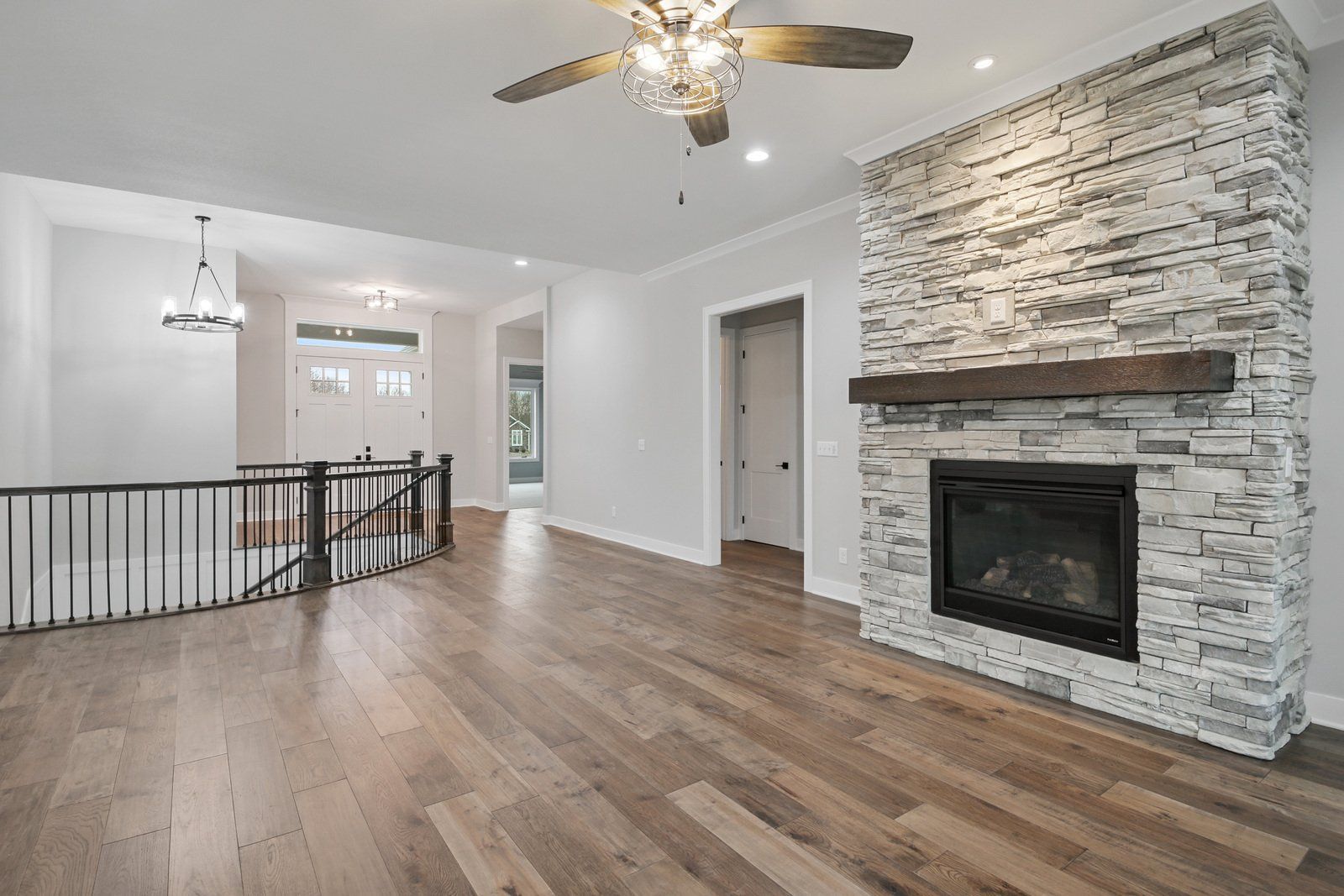 A living room with a fireplace and a ceiling fan.