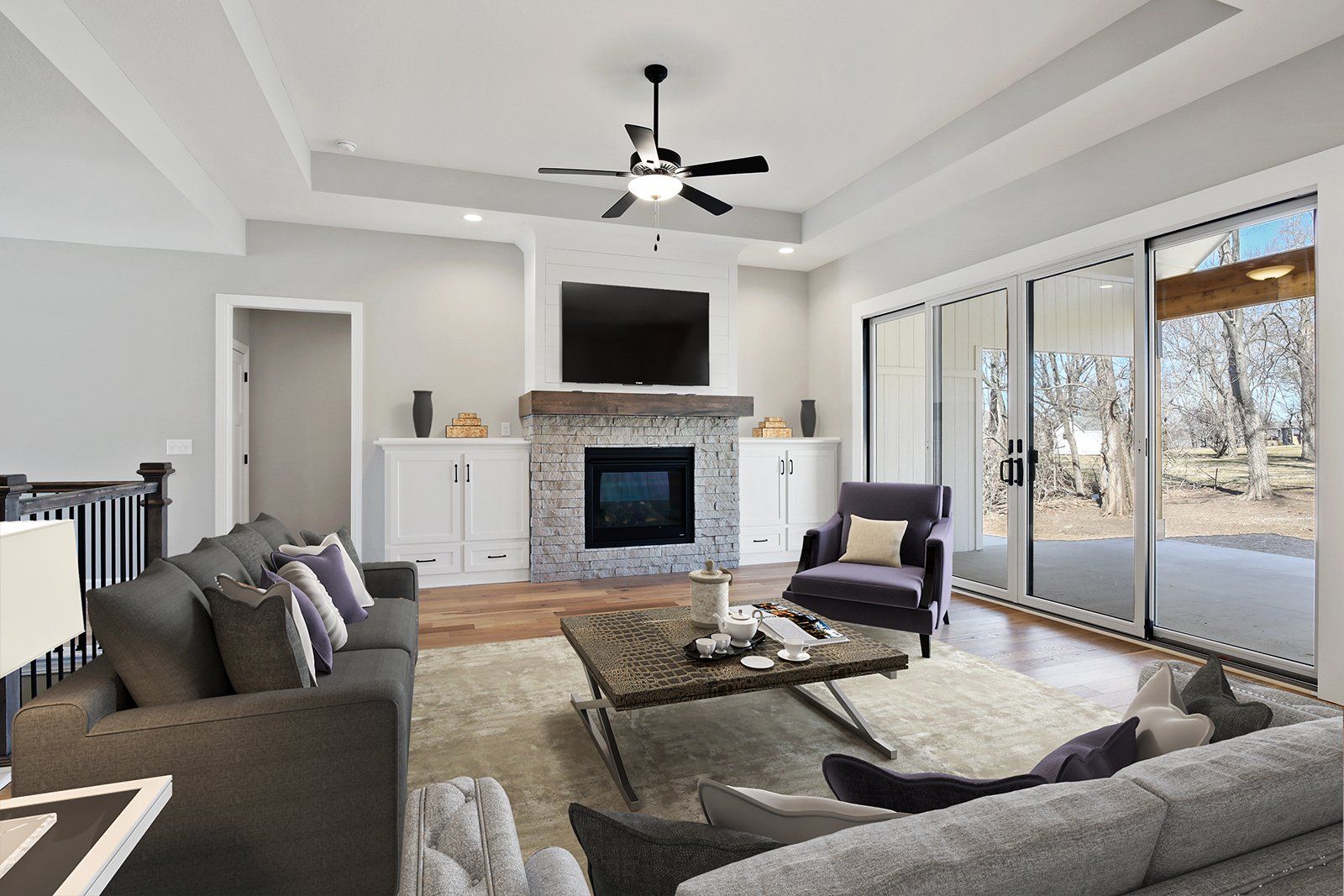 A living room with a couch , chair , coffee table , fireplace and television.