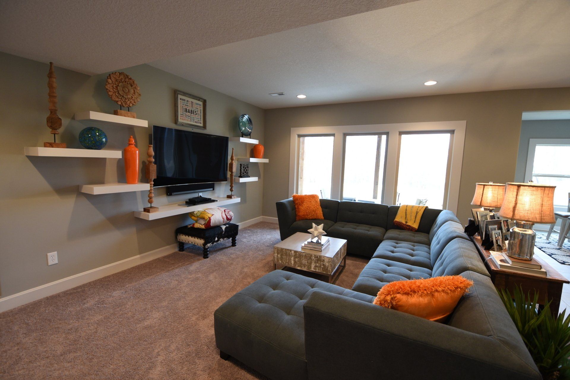 A living room with a large sectional couch and a flat screen tv.