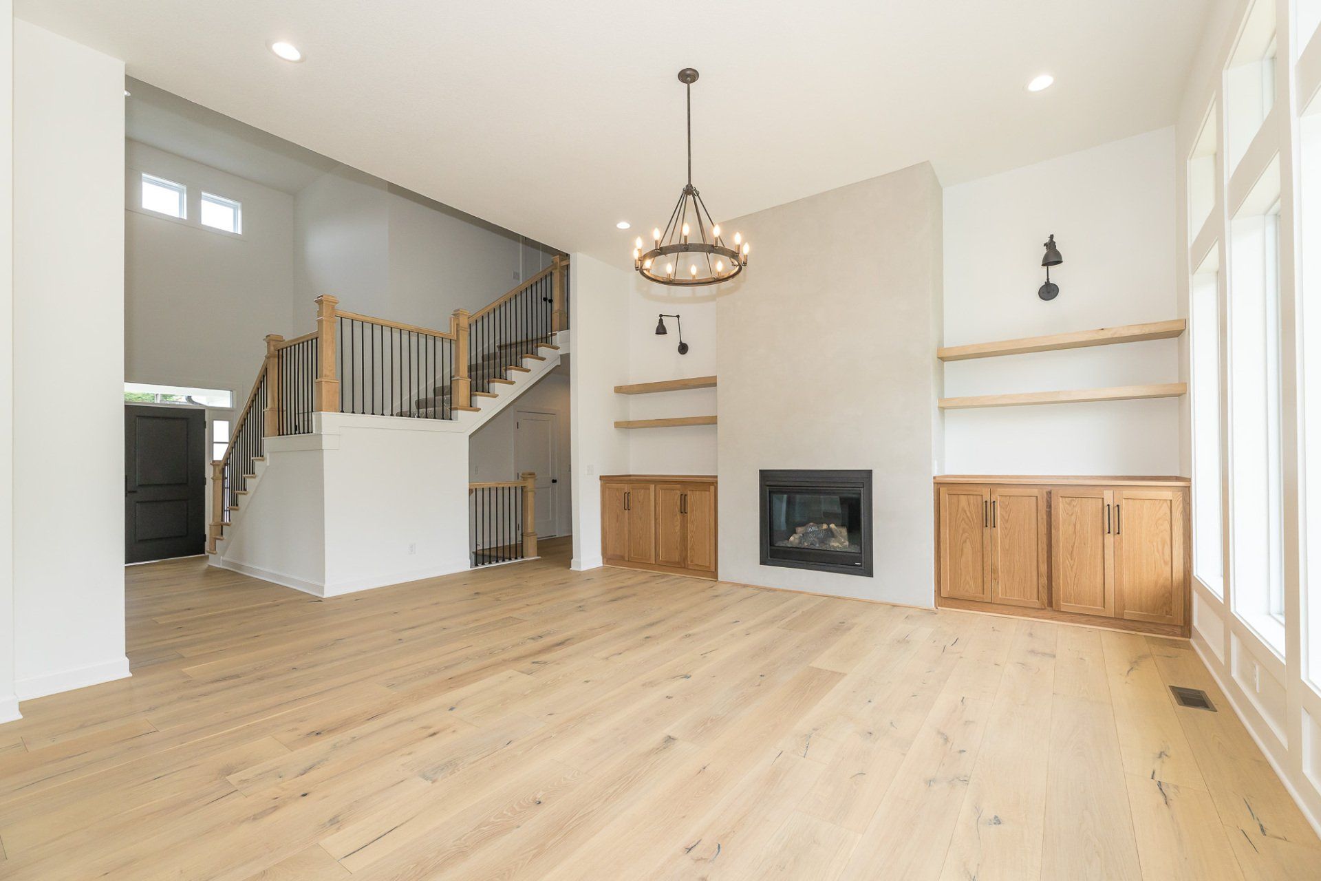 An empty living room with hardwood floors and a fireplace.