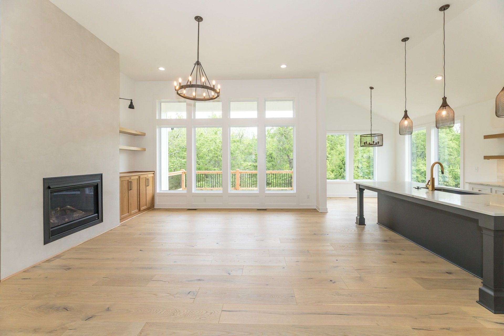 An empty living room with hardwood floors and a fireplace.