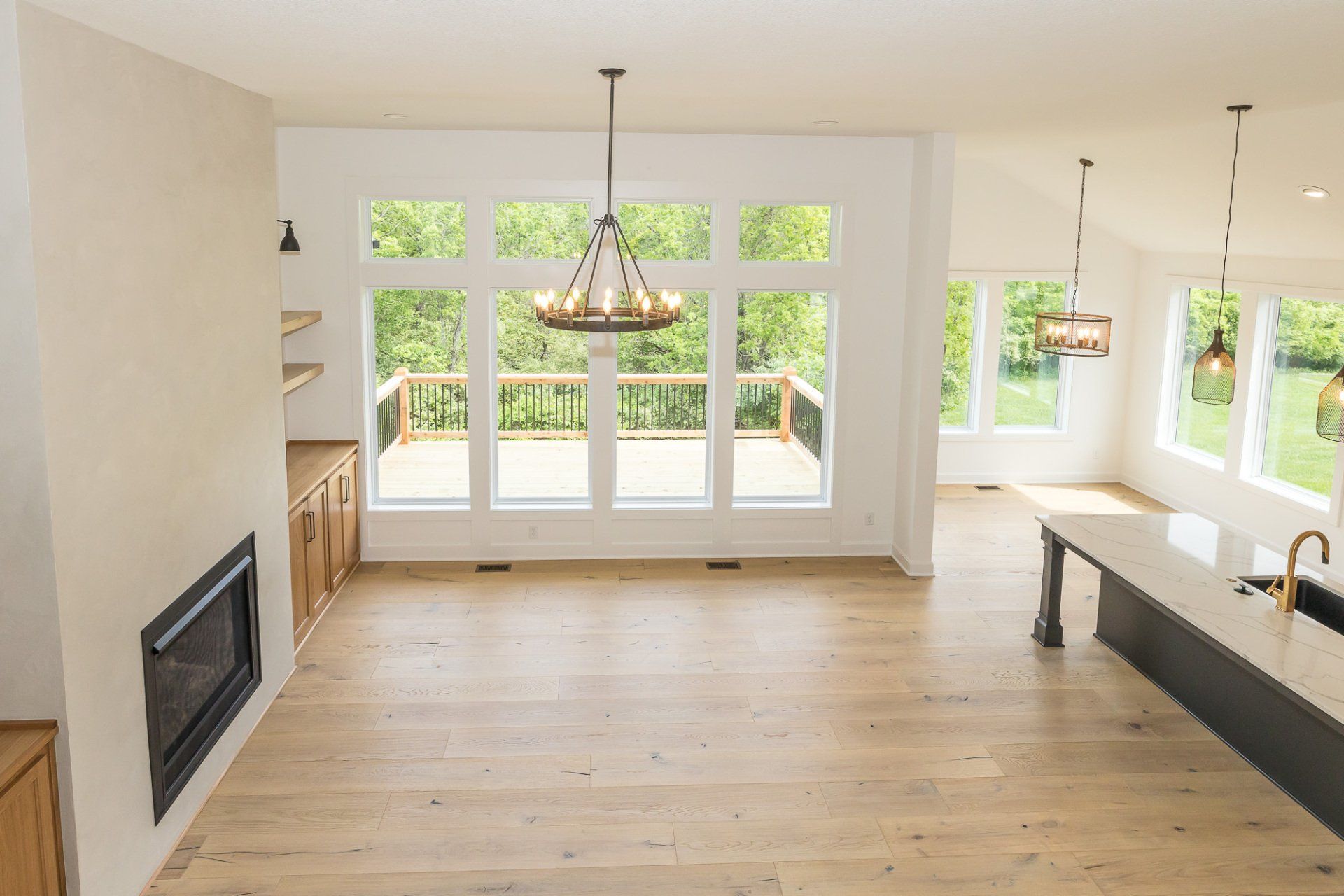 An empty living room with a fireplace and lots of windows.