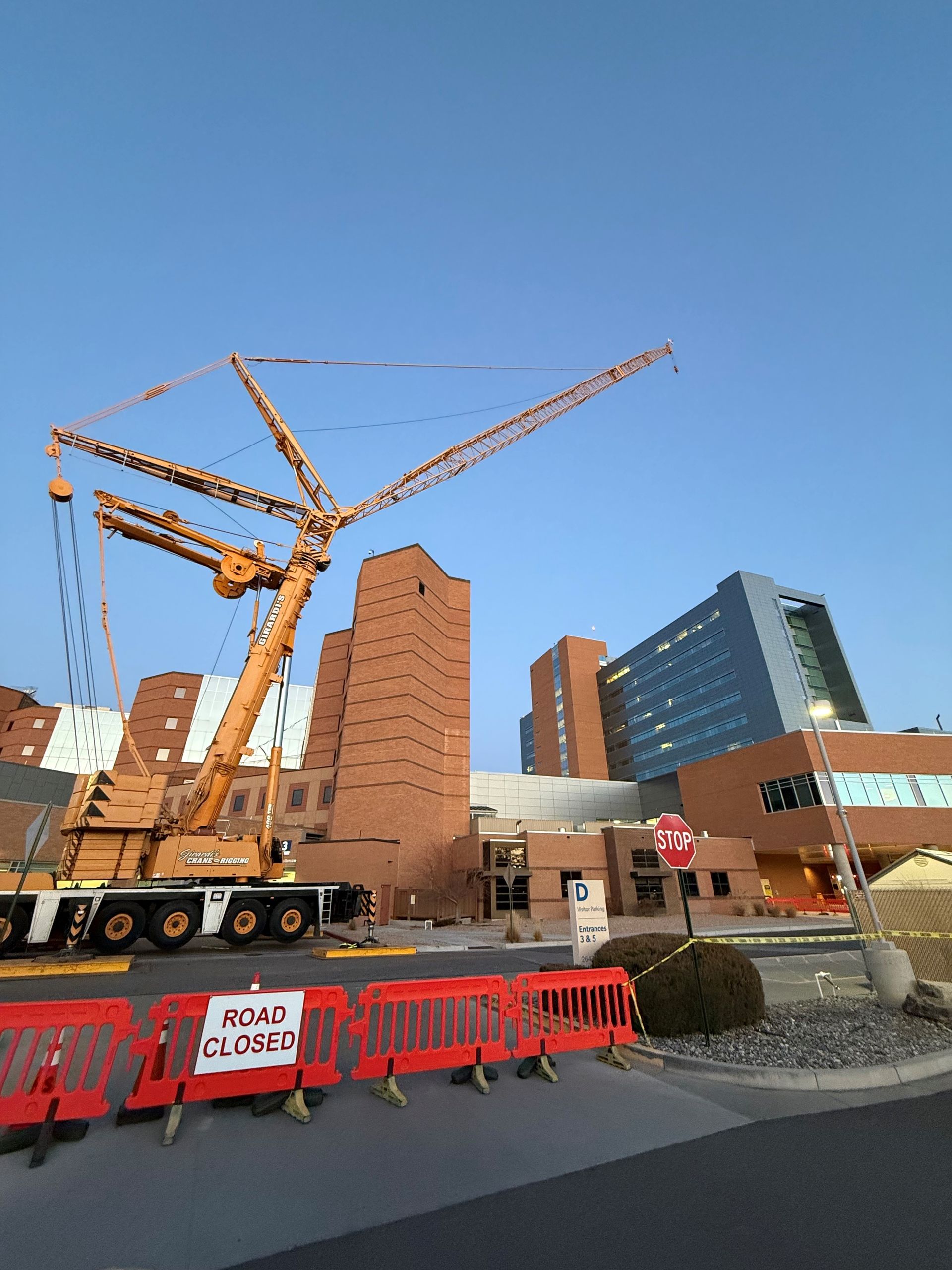 A large crane is being built in front of a hospital