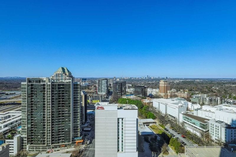 An aerial view of a city with lots of tall buildings and a blue sky.