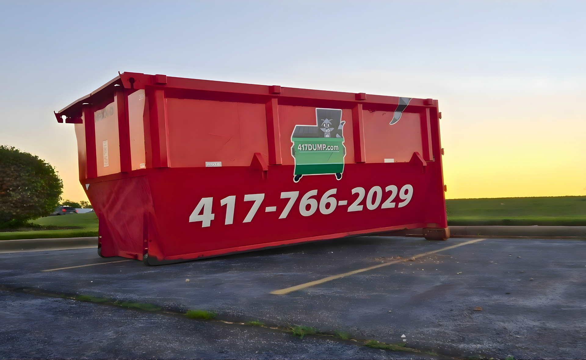 Red dumpster in a parking lot, with a phone number displayed.
