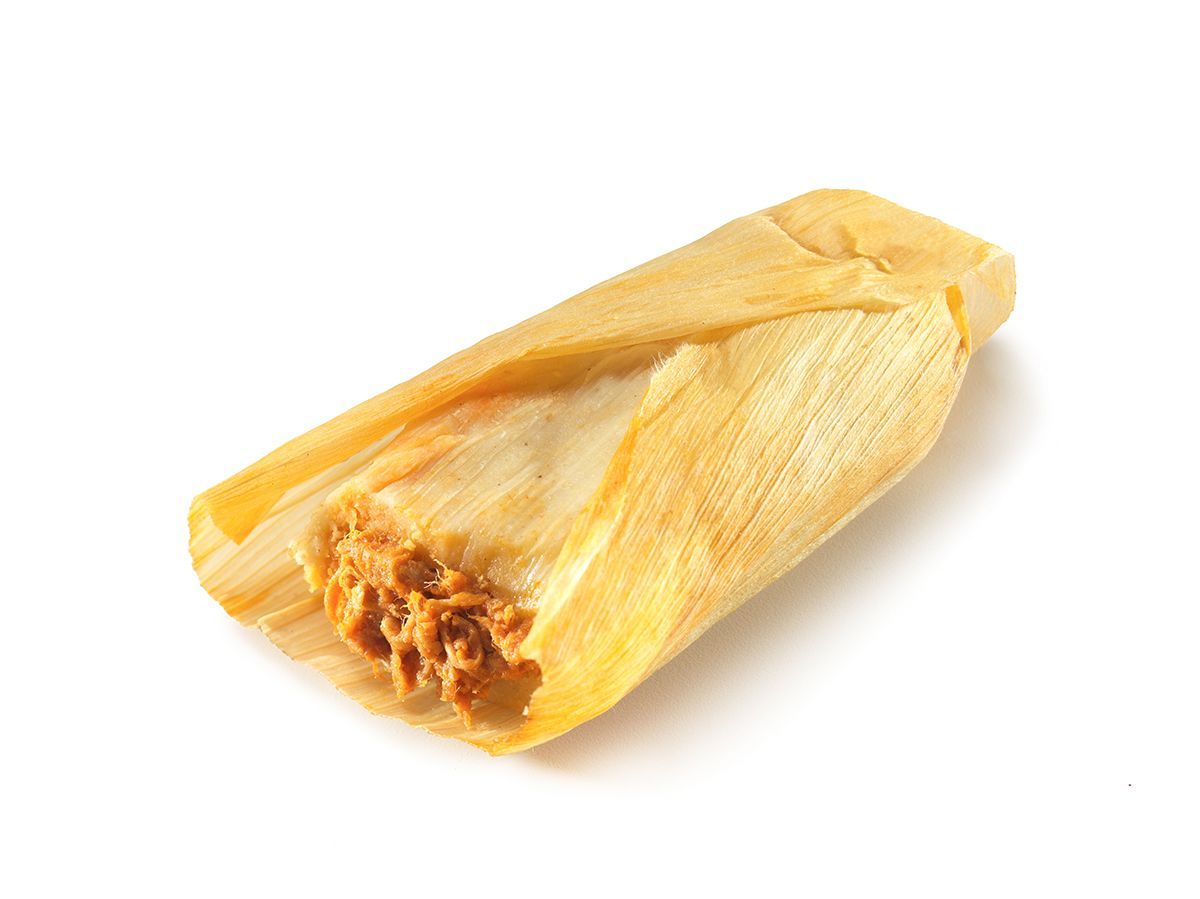 Yellow corn husk tamale with filling visible at one end, on a white background