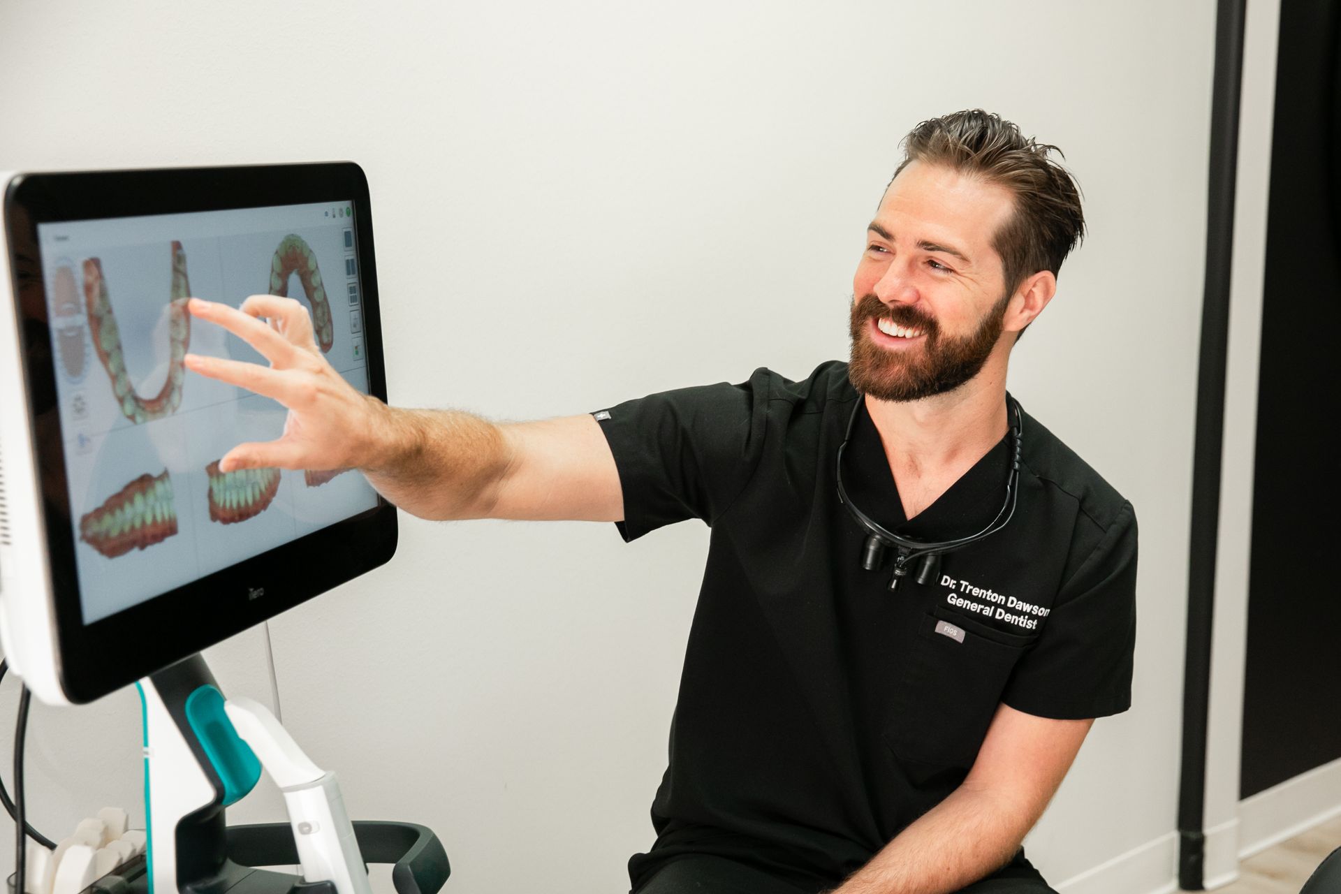 Man pointing at a touchscreen display in a clinical setting
