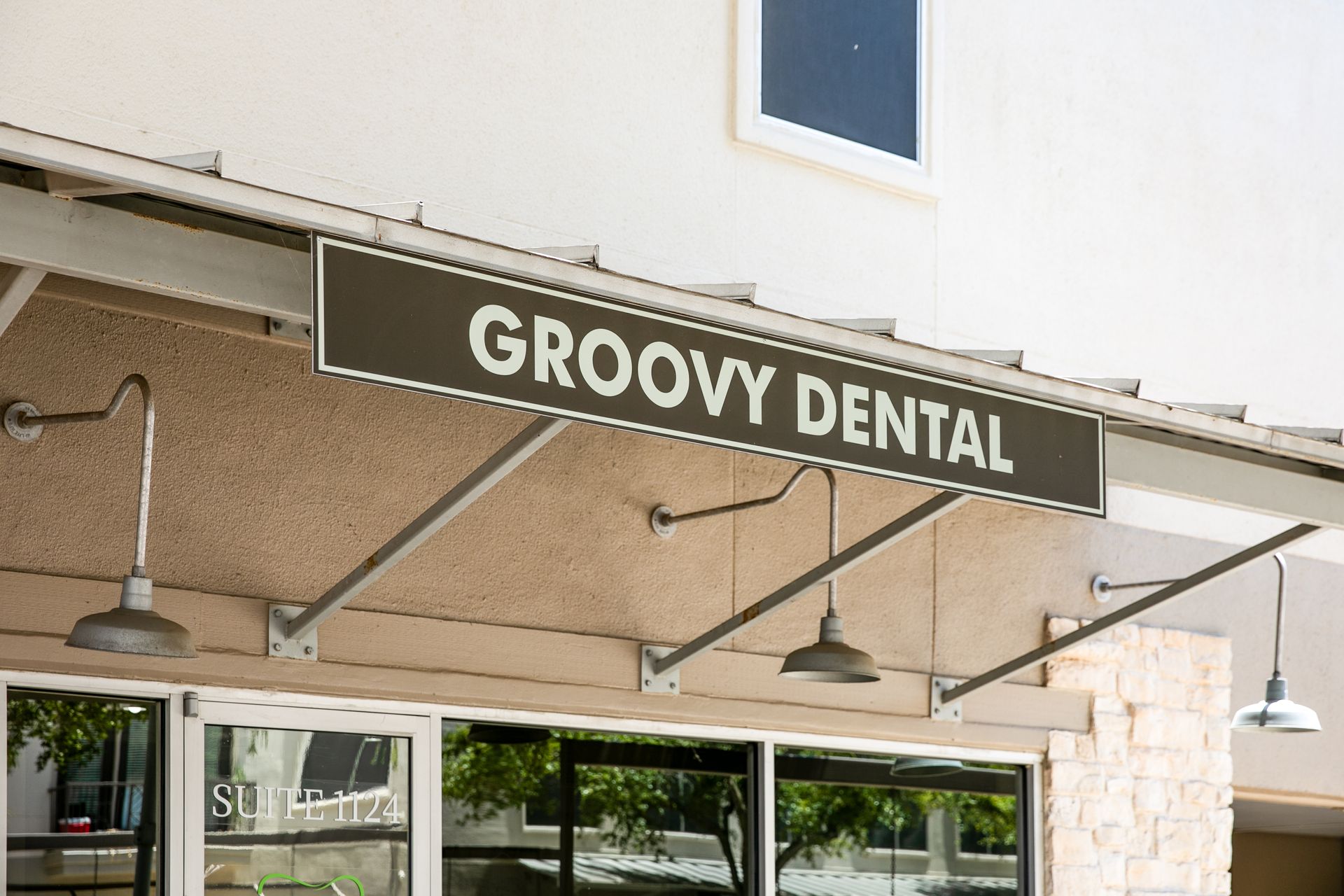 Groovy Dental storefront sign above glass entrance under a beige awning
