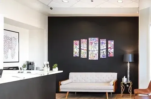 Modern lobby with black accent wall, white sofa, floral art, and floor lamp