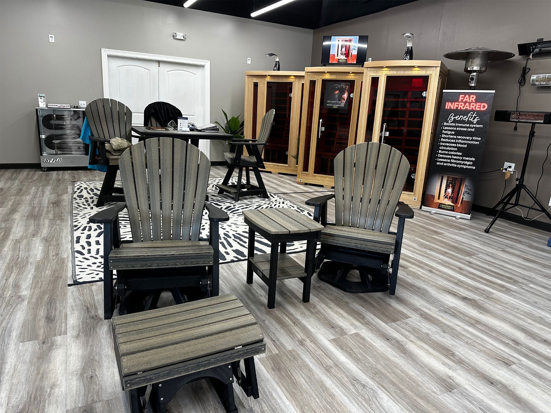 Inside a shop, Adirondack chairs, infrared saunas, and promotional banners are on display.