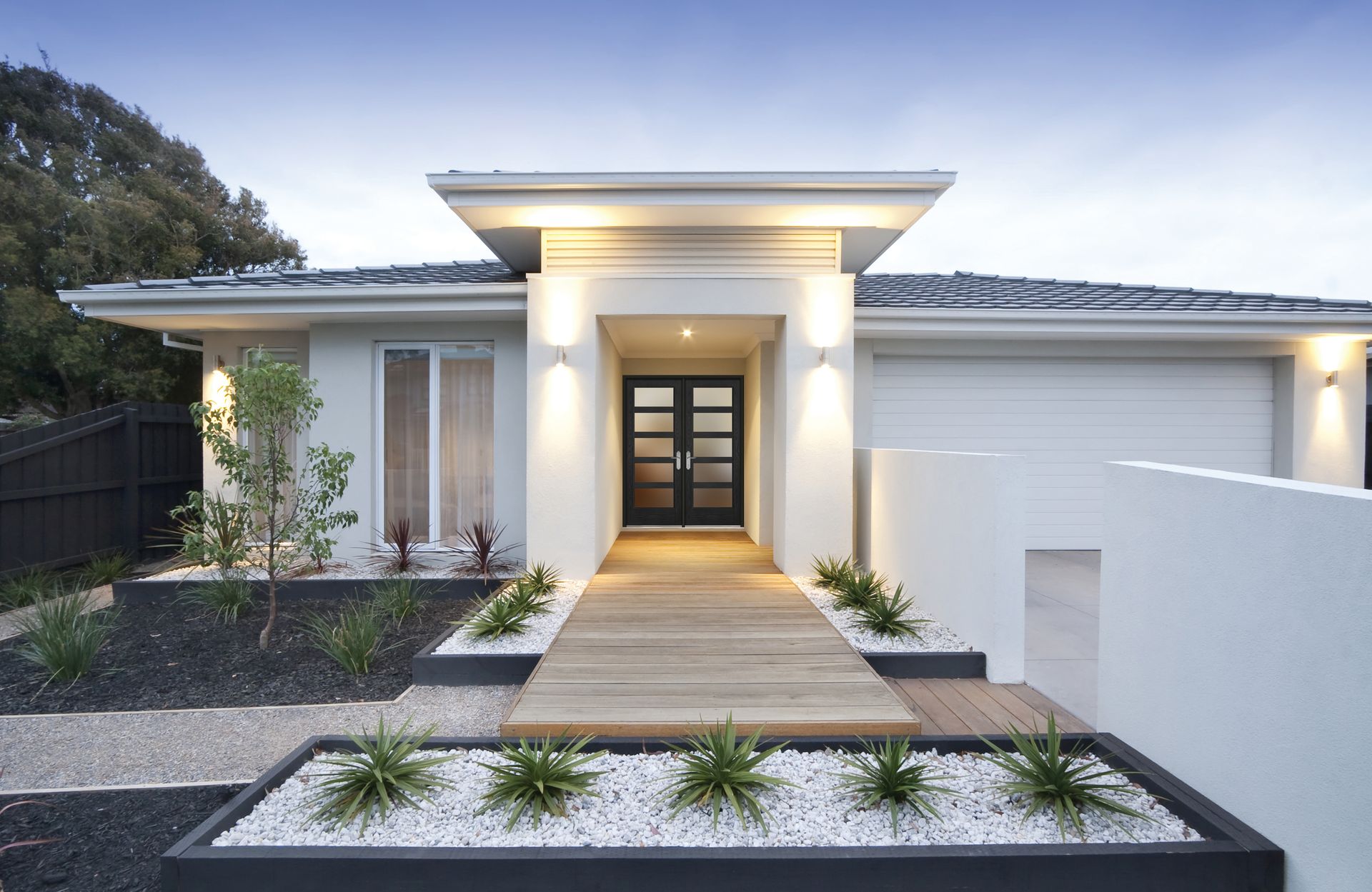 A white house with a wooden walkway leading to the front door