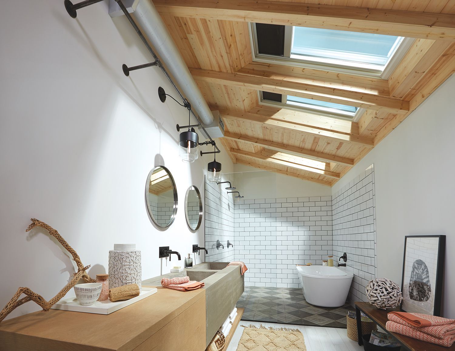 A bathroom with a skylight , sinks , mirrors and a bathtub.