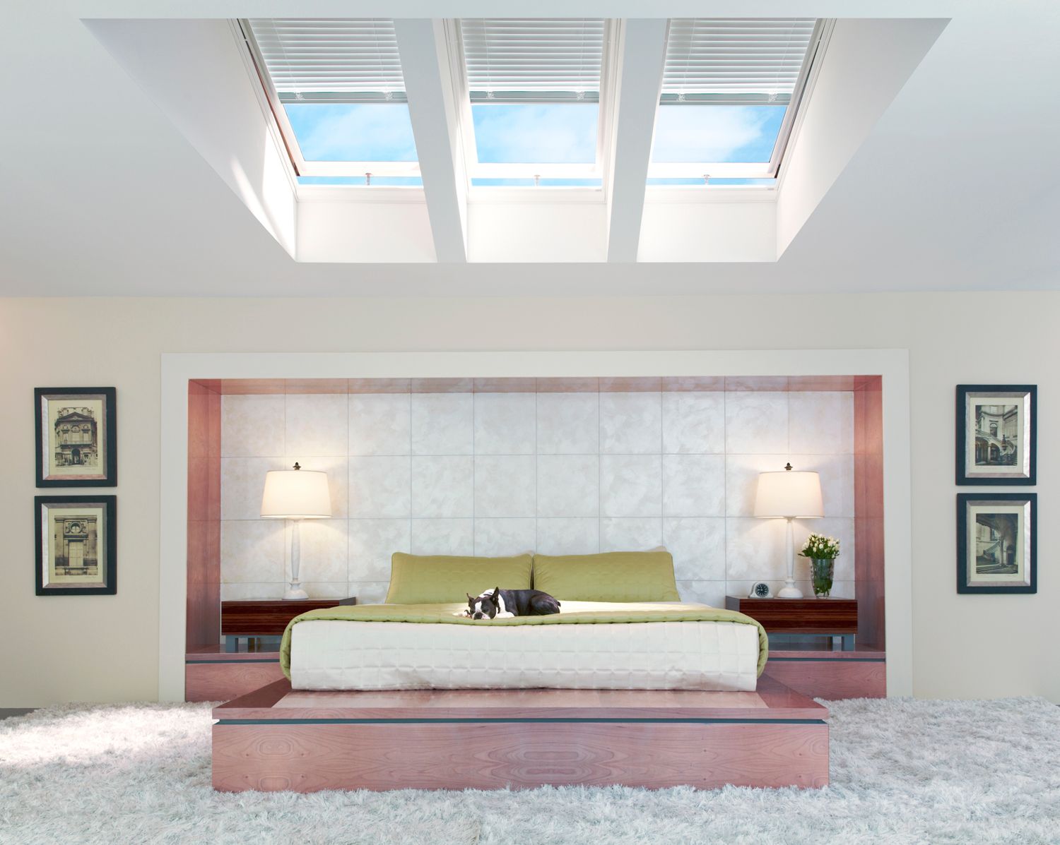 A bedroom with a large bed and skylights above it