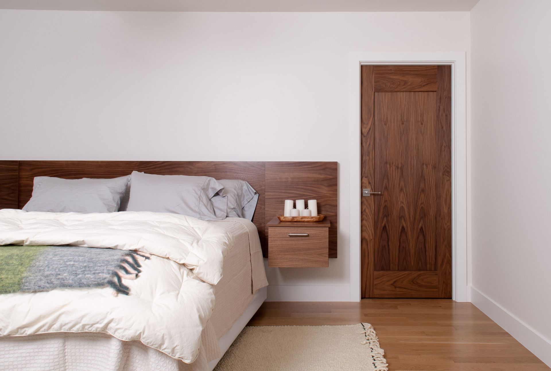 A bedroom with a bed , nightstand , and door.