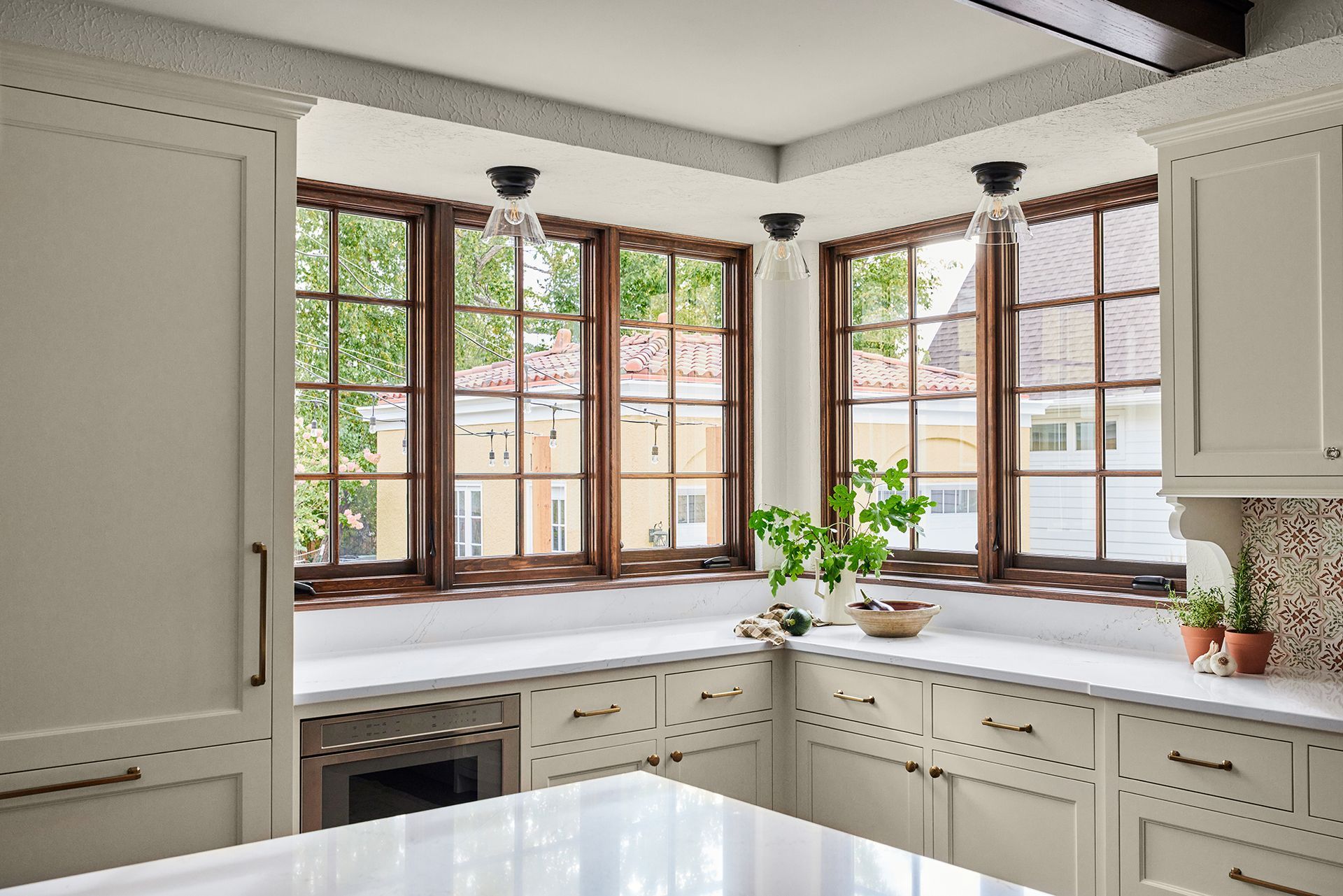 A kitchen with a lot of windows and white cabinets