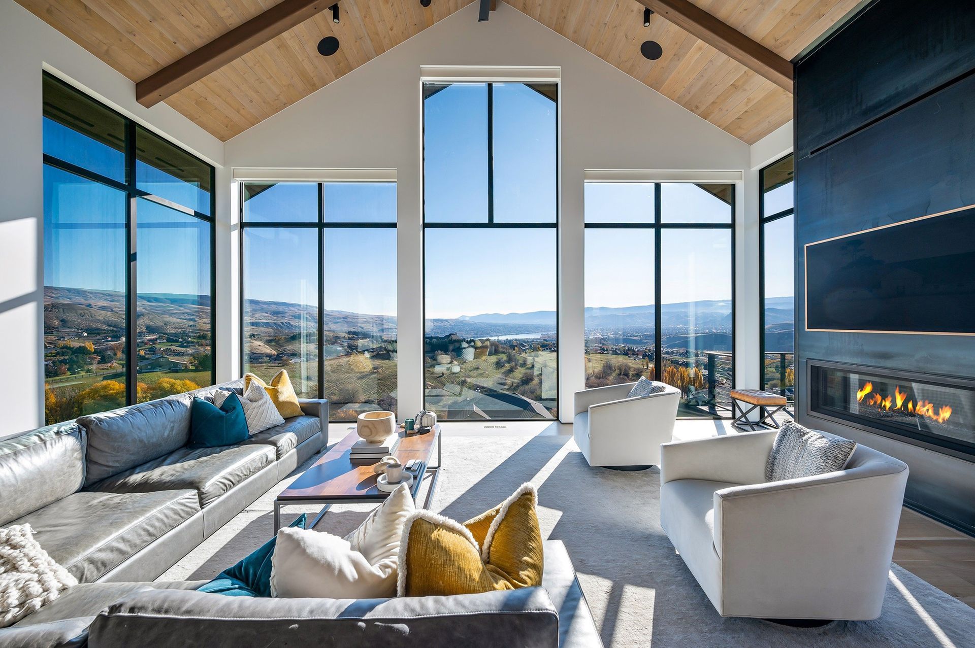 A living room with a lot of windows and a fireplace.