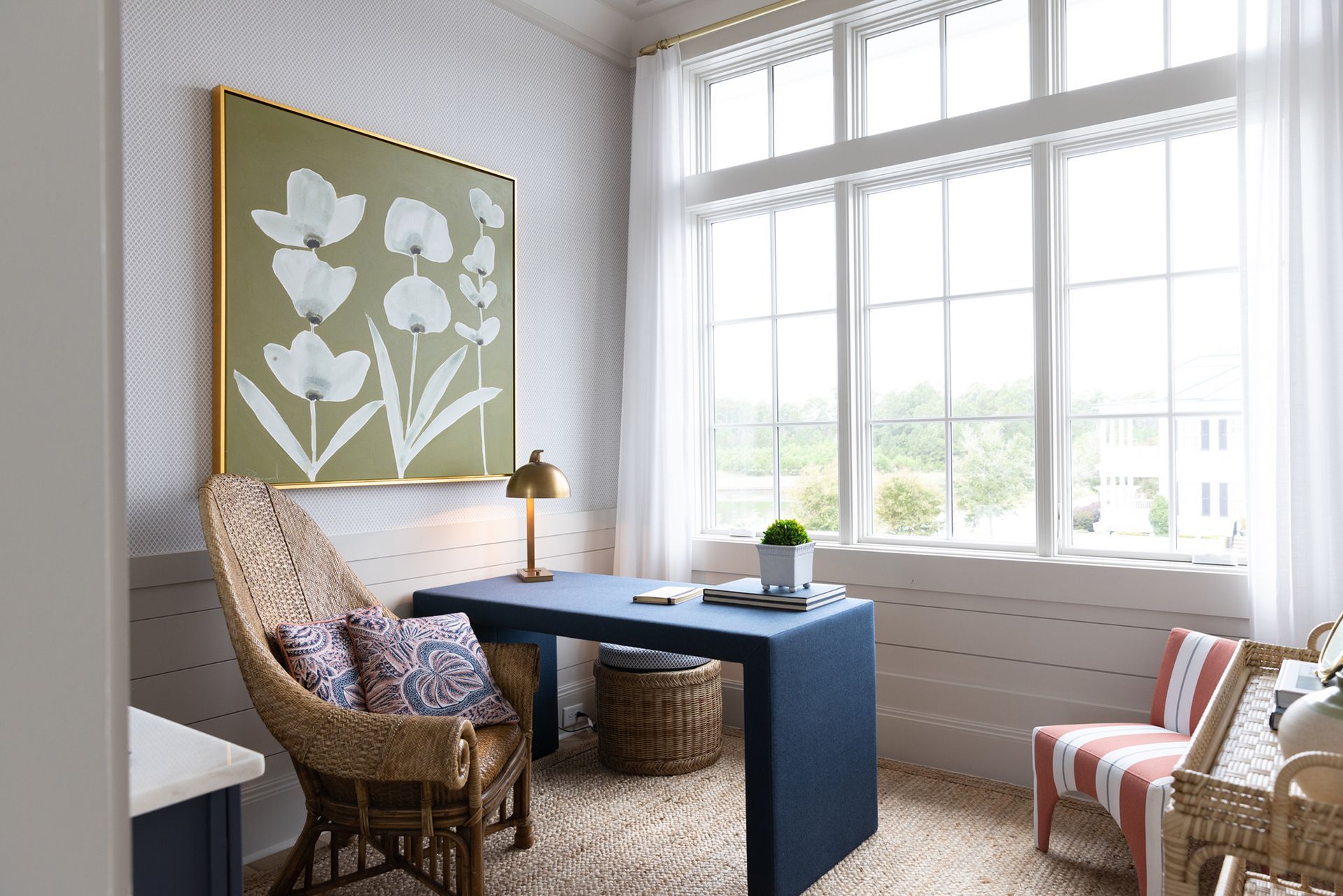 A home office with a desk, chairs, and a large window.