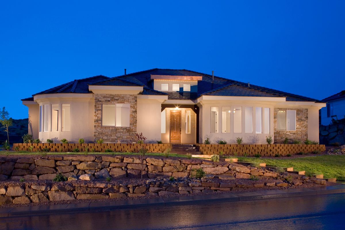 A large house is lit up at night in a residential area
