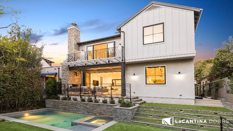 A large white house with a pool in the backyard.