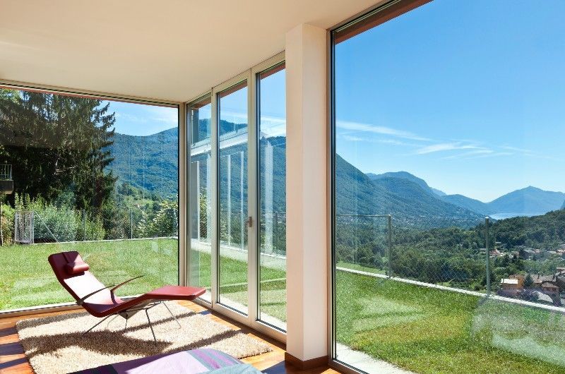 A living room with a chair and a view of the mountains.
